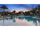 A resort-style pool with ample seating and palm trees overlooks a beautiful sunset at 9012 Tequila Sunrise Dr, Sarasota, FL 34241