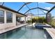 A view of the screened-in pool and spa area with waterfall and patio seating at 9012 Tequila Sunrise Dr, Sarasota, FL 34241