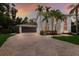 Elegant two-story home with lush landscaping, brick driveway, and a striking white facade at 9122 16Th Avenue Nw Cir, Bradenton, FL 34209
