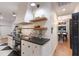 Modern kitchen featuring open shelving, black countertops, and stylish fixtures, next to a dining area at 9122 16Th Avenue Nw Cir, Bradenton, FL 34209