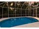 An in-ground pool enclosed with a screen with tropical foliage in the background at 9122 16Th Avenue Nw Cir, Bradenton, FL 34209