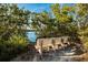 A peaceful lakeside setting with a wooden bench overlooking calm waters surrounded by lush green trees at 9122 16Th Avenue Nw Cir, Bradenton, FL 34209