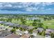 Picturesque aerial view of homes surrounded by a golf course and a scenic pond at 9123 Raes Creek Pl, Palmetto, FL 34221