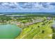 Stunning aerial view featuring a neighborhood by a lake and a golf course at 9123 Raes Creek Pl, Palmetto, FL 34221