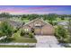 Charming tan house with a three-car garage, manicured lawn, and landscaping on a golf course at 9123 Raes Creek Pl, Palmetto, FL 34221