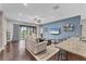 Open-concept living area featuring a ceiling fan, wood floors, and a large sliding glass door at 9123 Raes Creek Pl, Palmetto, FL 34221