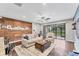 Open-concept living area featuring a ceiling fan, wood floors, and a large sliding glass door at 9123 Raes Creek Pl, Palmetto, FL 34221