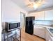 Bright kitchen with laminate floors, stainless microwave and black refrigerator at 1540 Pleasant Rd # G35, Bradenton, FL 34207