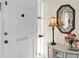 Bright foyer featuring a decorative mirror, elegant lamp, and floral arrangement on a marble-topped cabinet at 1060 Cockrill St # 1060, Venice, FL 34285