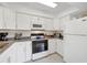 Bright kitchen featuring granite countertops, white cabinetry, and modern appliances at 1060 Cockrill St # 1060, Venice, FL 34285