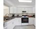 Well-lit kitchen with white cabinets, granite countertops, modern appliances, and ample workspace at 1060 Cockrill St # 1060, Venice, FL 34285