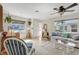 Bright living room features neutral tile flooring, a ceiling fan, and lots of natural light from large windows at 1060 Cockrill St # 1060, Venice, FL 34285