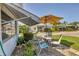 Outdoor patio with table, chairs, umbrella, and lush landscaping at 1060 Cockrill St # 1060, Venice, FL 34285