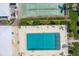 Aerial view showcasing a community pool and shuffleboard courts surrounded by manicured landscaping at 1060 Cockrill St # 1060, Venice, FL 34285