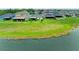 Backyard view of houses overlooking a green lawn extending to a lake in a beautiful neighborhood at 10609 Great Cormorant Dr, Riverview, FL 33579