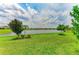 Lush backyard featuring green grass, a tranquil pond, and picturesque neighborhood homes at 10609 Great Cormorant Dr, Riverview, FL 33579