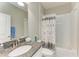Well-lit bathroom featuring a granite countertop and a shower with elegant shower curtain at 10609 Great Cormorant Dr, Riverview, FL 33579