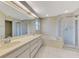 Well-lit bathroom featuring double sinks, soaking tub, and separate glass-enclosed shower at 1144 Hoover St, Nokomis, FL 34275