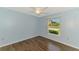 Bright bedroom with wood-look floors, a ceiling fan, and a view of the outdoors at 1144 Hoover St, Nokomis, FL 34275