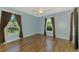 Bright blue bedroom featuring wood-look floors, two windows with curtains, and ceiling fan at 1144 Hoover St, Nokomis, FL 34275