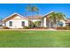 Charming single-story home featuring a well-manicured lawn, mature palm trees, and a welcoming facade under a clear blue sky at 1144 Hoover St, Nokomis, FL 34275
