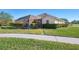 Sidewalk view of a home with green grass and hedges at 1144 Hoover St, Nokomis, FL 34275