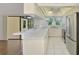 Bright kitchen featuring stainless steel appliances, white cabinets, and a sunlit breakfast bar at 1144 Hoover St, Nokomis, FL 34275
