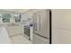 Well-lit kitchen with stainless steel refrigerator, oven, white countertops, and cabinetry at 1144 Hoover St, Nokomis, FL 34275