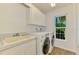 Bright laundry room with white cabinets, appliances, sink and window at 1144 Hoover St, Nokomis, FL 34275
