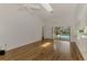 Open living room with wood-look tile floors, ceiling fans, and sliding door access to the pool at 1144 Hoover St, Nokomis, FL 34275