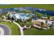 Aerial view of community amenities, including a pool, playground, and lush green spaces near a pond at 11685 Great Brook Ln, Parrish, FL 34219