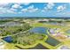 An aerial view of a community with multiple ponds, homes, and a construction site in the background at 11685 Great Brook Ln, Parrish, FL 34219