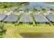 Aerial view of a well-maintained home with a screened lanai, lush landscaping, and water views at 11685 Great Brook Ln, Parrish, FL 34219