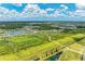 An aerial view of a community with a walking path, pond, green space, and neighborhood homes at 11685 Great Brook Ln, Parrish, FL 34219