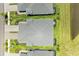 An aerial view of a home with a grey roof, screened lanai, pond, and green landscaping at 11685 Great Brook Ln, Parrish, FL 34219