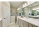 This bathroom features double sinks, modern lighting, and a glass-enclosed shower at 11685 Great Brook Ln, Parrish, FL 34219