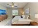 This bedroom features a ceiling fan, a television, and a window that lets in natural light at 11685 Great Brook Ln, Parrish, FL 34219