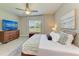 This bedroom features a ceiling fan, a television, and a window that lets in natural light at 11685 Great Brook Ln, Parrish, FL 34219