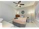 This bedroom features a ceiling fan, a mirror on the wall, and a window that lets in natural light at 11685 Great Brook Ln, Parrish, FL 34219