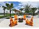 Outdoor fire pit area with Adirondack chairs and scenic landscaping with palm trees at 11685 Great Brook Ln, Parrish, FL 34219