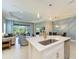 Modern kitchen featuring a spacious island, stainless steel appliances, and a view of the living area and outdoor patio at 11685 Great Brook Ln, Parrish, FL 34219