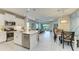 Open-concept kitchen with a large island, stainless steel appliances, and seamless flow into the dining and living areas at 11685 Great Brook Ln, Parrish, FL 34219