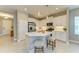 Bright, open kitchen with white cabinets, stainless steel appliances, and a center island featuring bar stool seating at 11685 Great Brook Ln, Parrish, FL 34219