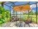The cozy screened lanai features comfortable seating, an outdoor grill, and serene water views at 11685 Great Brook Ln, Parrish, FL 34219