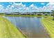 Aerial view of a large pond surrounded by green lawns and various homes in the distance at 11685 Great Brook Ln, Parrish, FL 34219