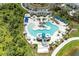 Aerial view of a resort-style pool with a slide, cabanas, lounge chairs and lush landscaping at 11685 Great Brook Ln, Parrish, FL 34219