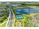 Aerial view of tennis and pickleball courts near a scenic pond and walking path at 11685 Great Brook Ln, Parrish, FL 34219