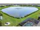 An aerial view showcasing a large lake with a fountain, well-maintained green spaces, and a screened pool area at 12564 Night View Dr, Sarasota, FL 34238