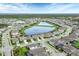 A wide aerial shot of the neighborhood with ponds, fountains, sidewalks, and neatly arranged homes with pools at 12564 Night View Dr, Sarasota, FL 34238
