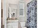Well-lit bathroom with a modern sink and vanity, toilet, and shower featuring a stylish curtain at 12564 Night View Dr, Sarasota, FL 34238
